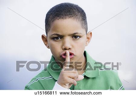 Stock Image - Boy with finger in front of mouth. Fotosearch