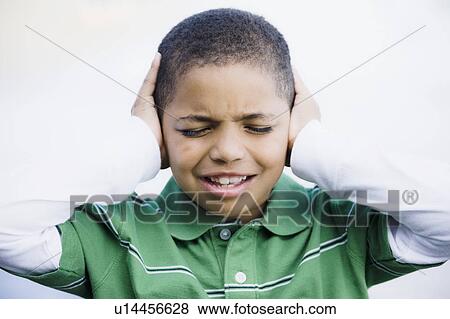Stock Photo - Boy with hands over ears. Fotosearch