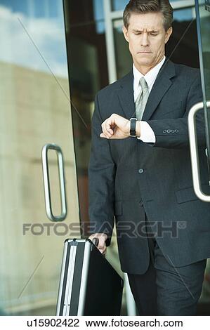 Businessman looking at watch View Large Photo Image Stock Image - Businessman looking at watch. Fotosearch