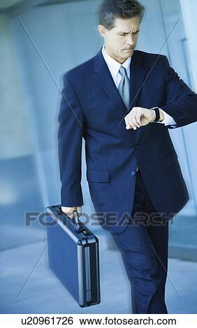 Stock Photograph - Businessman looking at watch. Fotosearch