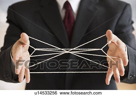 Stock Photograph - Businessman with cat's cradle strings. Fotosearch