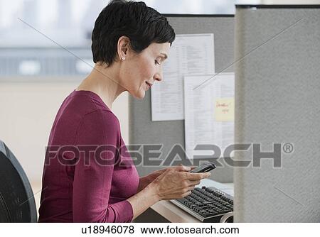 Stock Photo - Businesswoman sitting at desk. Fotosearch