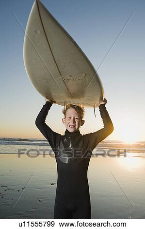 Stock Photo - Child holding surfboard. Fotosearch