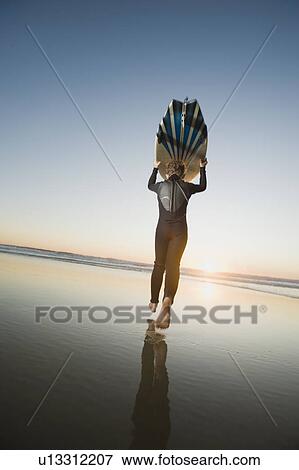 Stock Photo - Child holding surfboard. Fotosearch