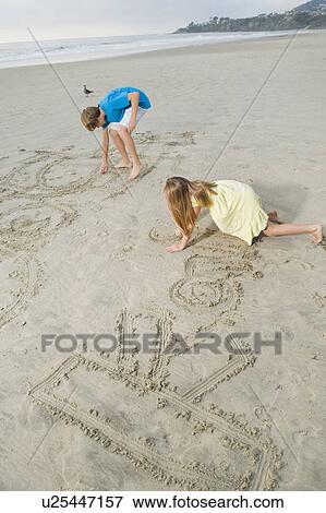 Stock Photo - Children writing on beach. Fotosearch