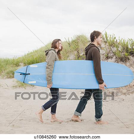 Couple carrying surfboard View Large Photo Image Stock Image - Couple carrying surfboard. Fotosearch