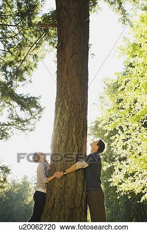 Stock Image - Couple hugging tree. Fotosearch
