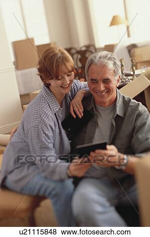 Couple looking at photograph View Large Photo Image Stock Photo - Couple looking at photograph. Fotosearch