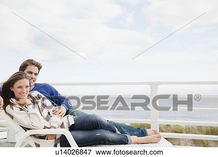 Couple on lounge chair View Large Photo Image Stock Photo - Couple on lounge chair. Fotosearch