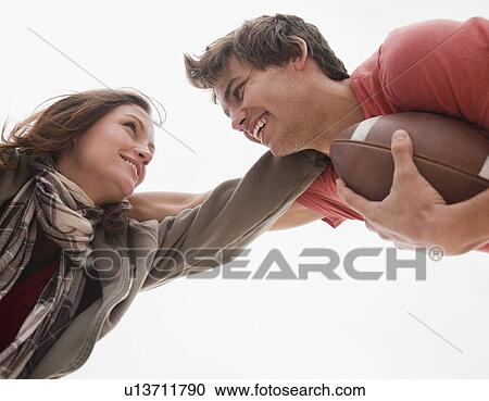 Stock Image - Couple playing football. Fotosearch