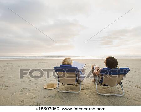 Couple relaxing at the beach View Large Photo Image Stock Image - Couple relaxing at the beach. Fotosearch