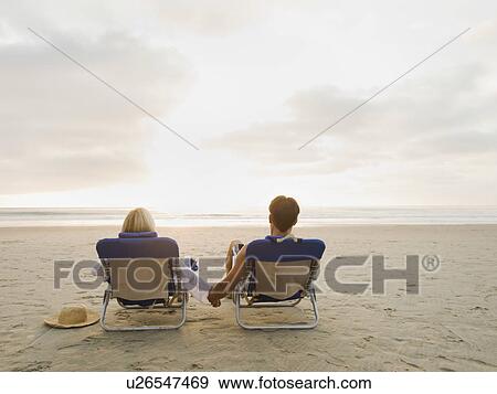 Couple relaxing at the beach View Large Photo Image Stock Photo - Couple relaxing at the beach. Fotosearch