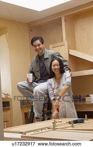 Stock Photo - Couple remodeling kitchen. Fotosearch