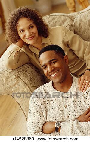 Stock Image - Couple sitting together at home. Fotosearch