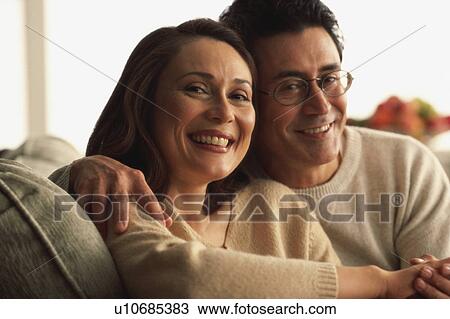 Stock Image - Couple together on couch. Fotosearch