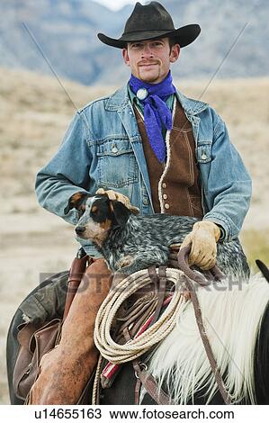 Stock Image - Cowboy and dog on horse. Fotosearch