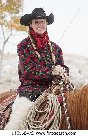Stock Image - Cowgirl on horse. Fotosearch