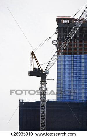 Stock Image - Crane beside high-rise building. Fotosearch