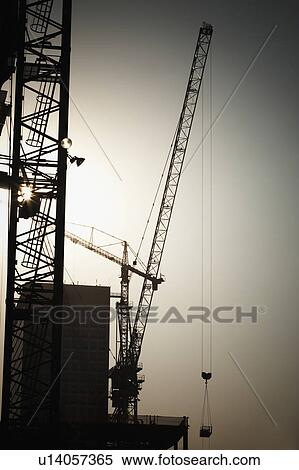 Stock Photography - Cranes and high-rise building under construction. Fotosearch