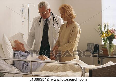 Stock Image - Doctor talking to patient. Fotosearch
