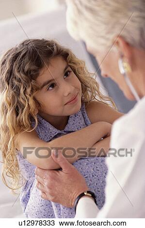 Doctor talking to young girl View Large Photo Image Stock Image - Doctor talking to young girl. Fotosearch