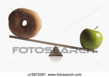Stock Image - Donut and apple balanced on teeter totter. Fotosearch