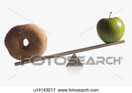 Donut and apple balanced on teeter totter View Large Photo Image Stock Photo - Donut and apple balanced on teeter totter. Fotosearch