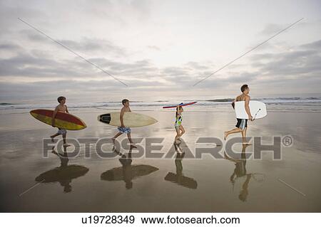 Stock Photo - Family carrying surfboards. Fotosearch
