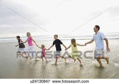 Family holding hands in ocean View Large Photo Image Stock Photo - Family holding hands in ocean. Fotosearch