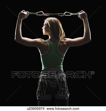 Picture - Female climber holding gear. Fotosearch