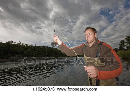 Stock Image - Fly fisherman casting. Fotosearch
