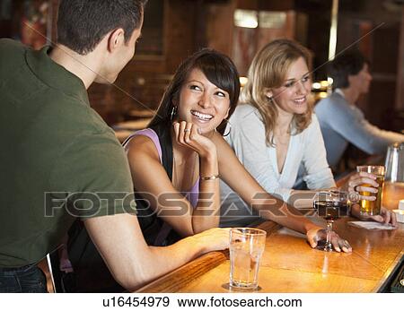 Friends drinking at bar View Large Photo Image Stock Photo - Friends drinking at bar. Fotosearch