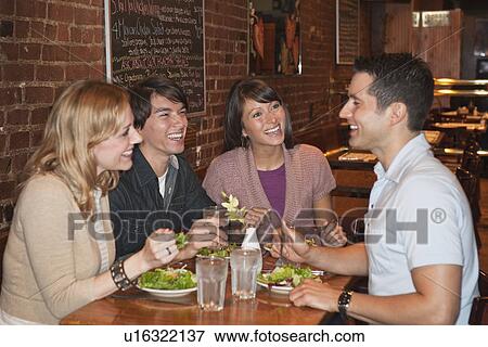 Stock Photo - Friends eating at restaurant. Fotosearch