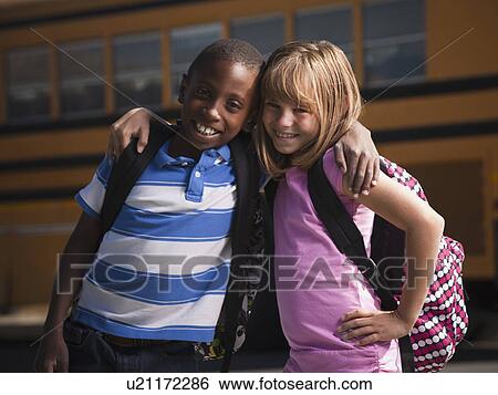 Stock Photograph - Friends in front of school bus. Fotosearch