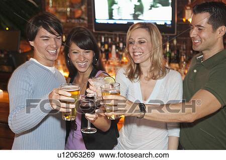 Friends toasting at bar View Large Photo Image Stock Photo - Friends toasting at bar. Fotosearch