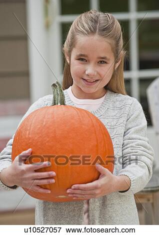 Stock Photo - Girl holding pumpkin. Fotosearch