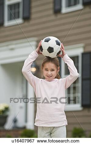 Girl holding soccer ball on head View Large Photo Image Stock Photo - Girl holding soccer ball on head. Fotosearch