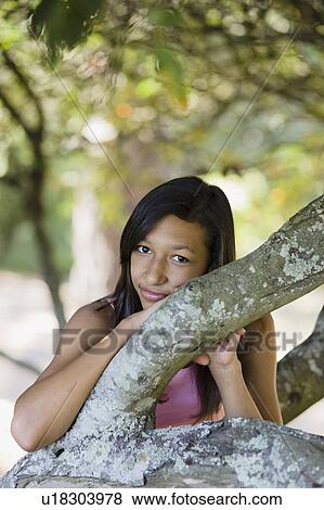 Stock Photo - Girl leaning on tree. Fotosearch