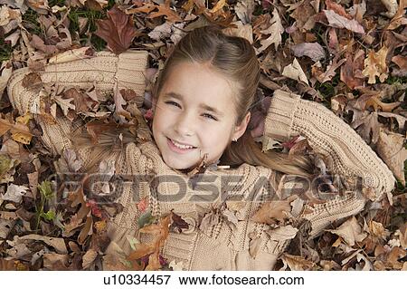 Stock Photo - Girl lying in leaves. Fotosearch