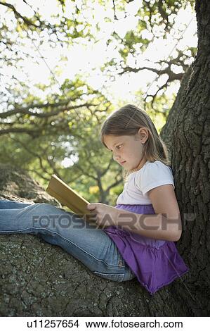Girl reading book in tree View Large Photo Image Picture - Girl reading book in tree. Fotosearch