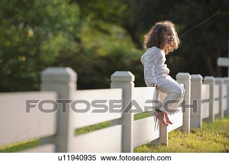Stock Photography - Girl sitting on fence. Fotosearch