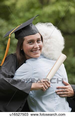 Stock Image - Graduate hugs elderly woman. Fotosearch