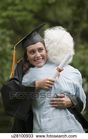 Stock Image - Graduate hugs elderly woman. Fotosearch