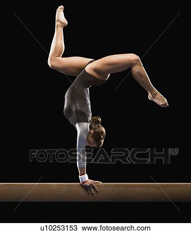 Stock Image - Gymnast on balance beam. Fotosearch