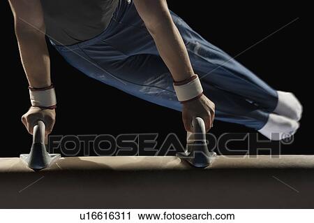 Stock Image - Gymnast swinging on pommel horse. Fotosearch