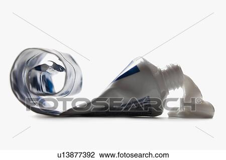 Stock Image - Half empty toothpaste tube spilling. Fotosearch