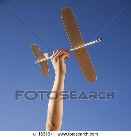 Stock Image - Hand holding toy plane. Fotosearch