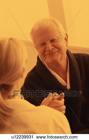 Stock Image - Healthcare worker talking to senior. Fotosearch