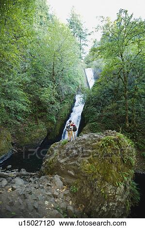 Hikers in front of waterfall View Large Photo Image Stock Image - Hikers in front of waterfall. Fotosearch