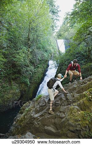 Hikers in front of waterfall View Large Photo Image Stock Image - Hikers in front of waterfall. Fotosearch